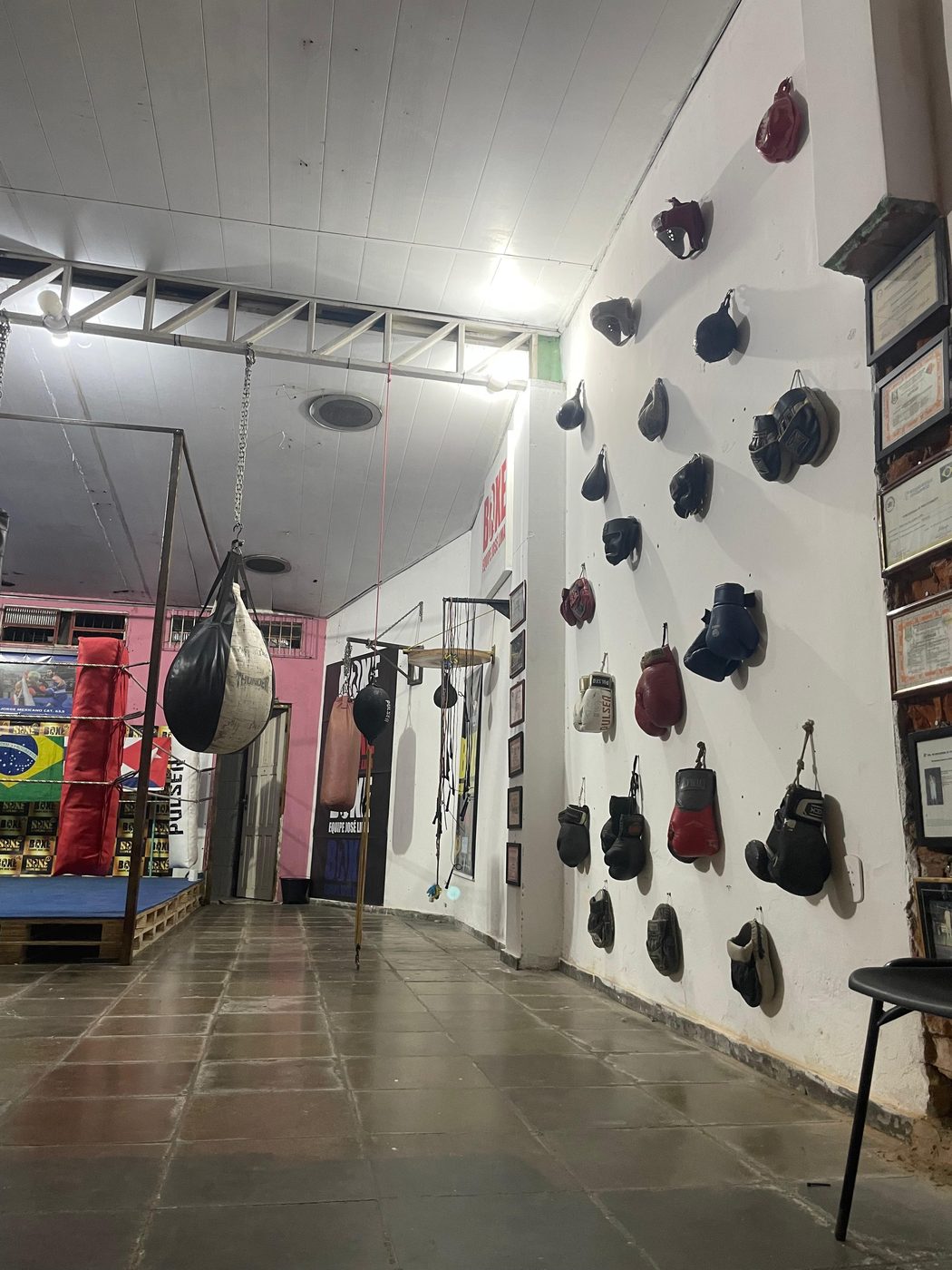 Vista panorâmica do CT Equipe José Lima mostrando ringue, sacos e parede de luvas